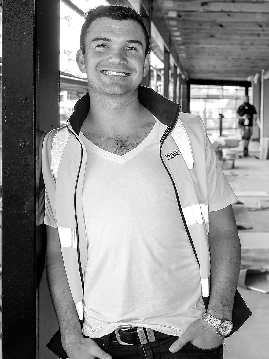Matthew Horncastle in a Williams Corporation hi-vis vest, on the walkway of a multi-unit residential development under construction